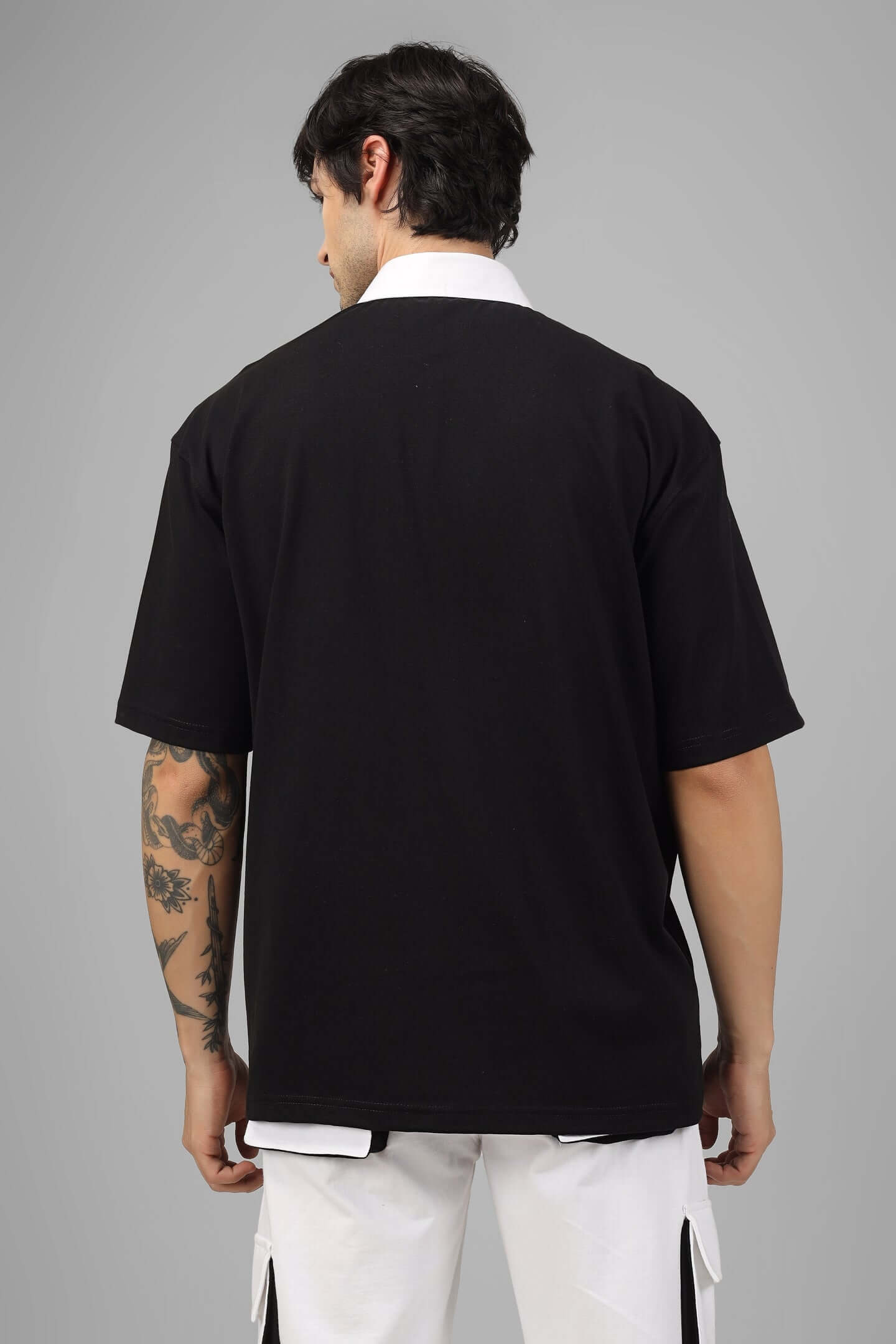 Man wearing SAGOL black oversized polo t-shirt, half sleeves, made with 100% cotton fabric, styled for comfortable all-day wear.