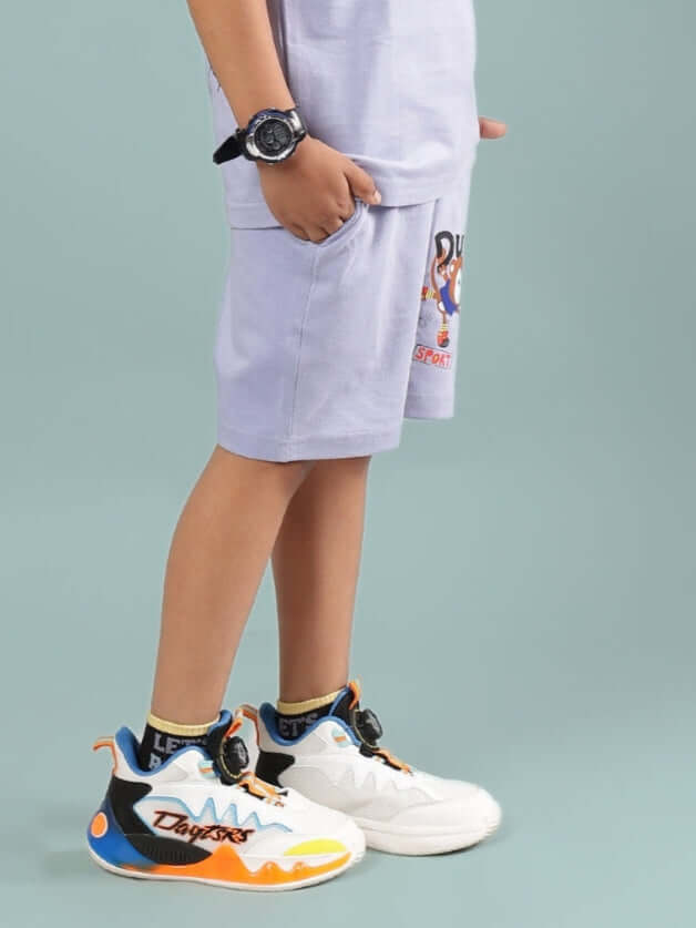 Boy wearing SAMMY SHORTS FOR BOYS & GIRLS LAVENDER with colorful sneakers