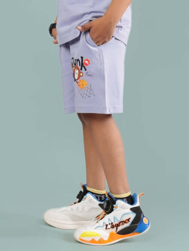 Side view of SAMMY SHORTS FOR BOYS & GIRLS LAVENDER with cartoon print, worn by a child, paired with colorful sneakers.