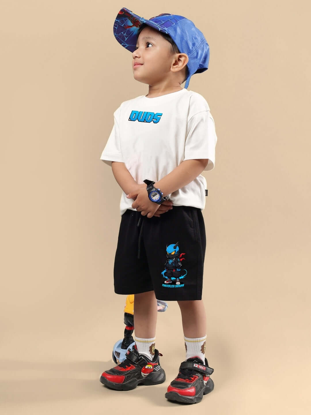 Child wearing SAMURAI PRINTED CO-ORD FOR BOYS & GIRLS OFF WHITE BLACK with blue hat and sneakers.