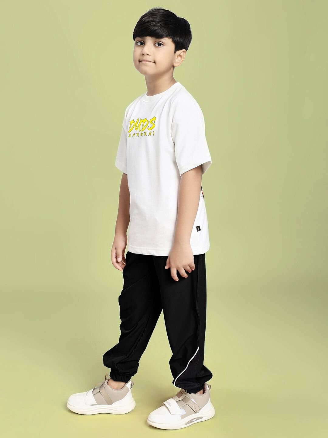 SAMURAI SOUL PRINTED CO-ORD FOR BOYS AND GIRLS WHITE BLACK, stylish outfit worn by a boy, side view against a green background.
