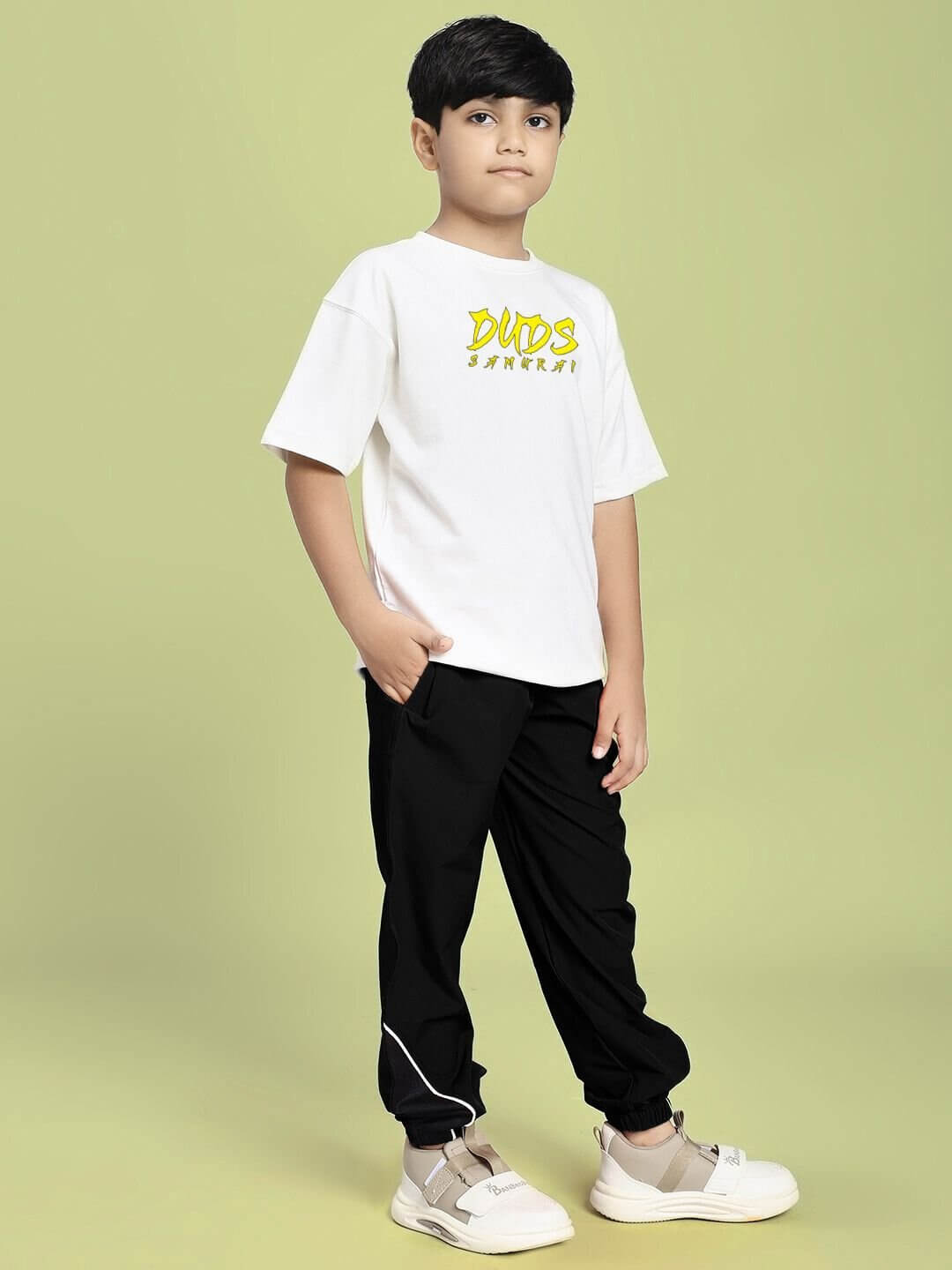 Child wearing SAMURAI SOUL PRINTED CO-ORD FOR BOYS AND GIRLS WHITE BLACK on a beige background.