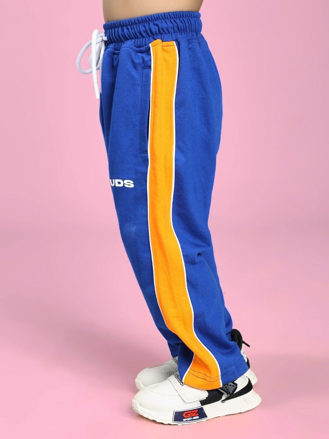 Child wearing SANFORD STRIPE JOGGER FOR BOYS AND GIRLS BLUE with bold orange stripe detailing on the leg.