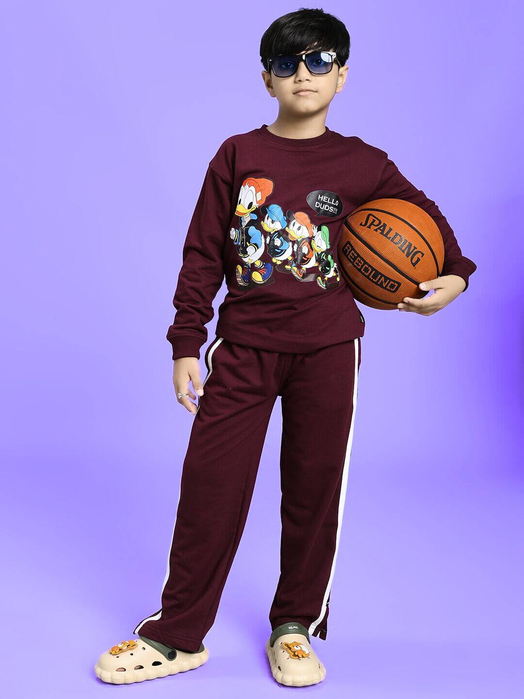 Child wearing SCHOOL DAYS CO-ORD FOR BOYS GIRLS MAROON, holding a basketball, showcasing trendy comfort and style for kids.