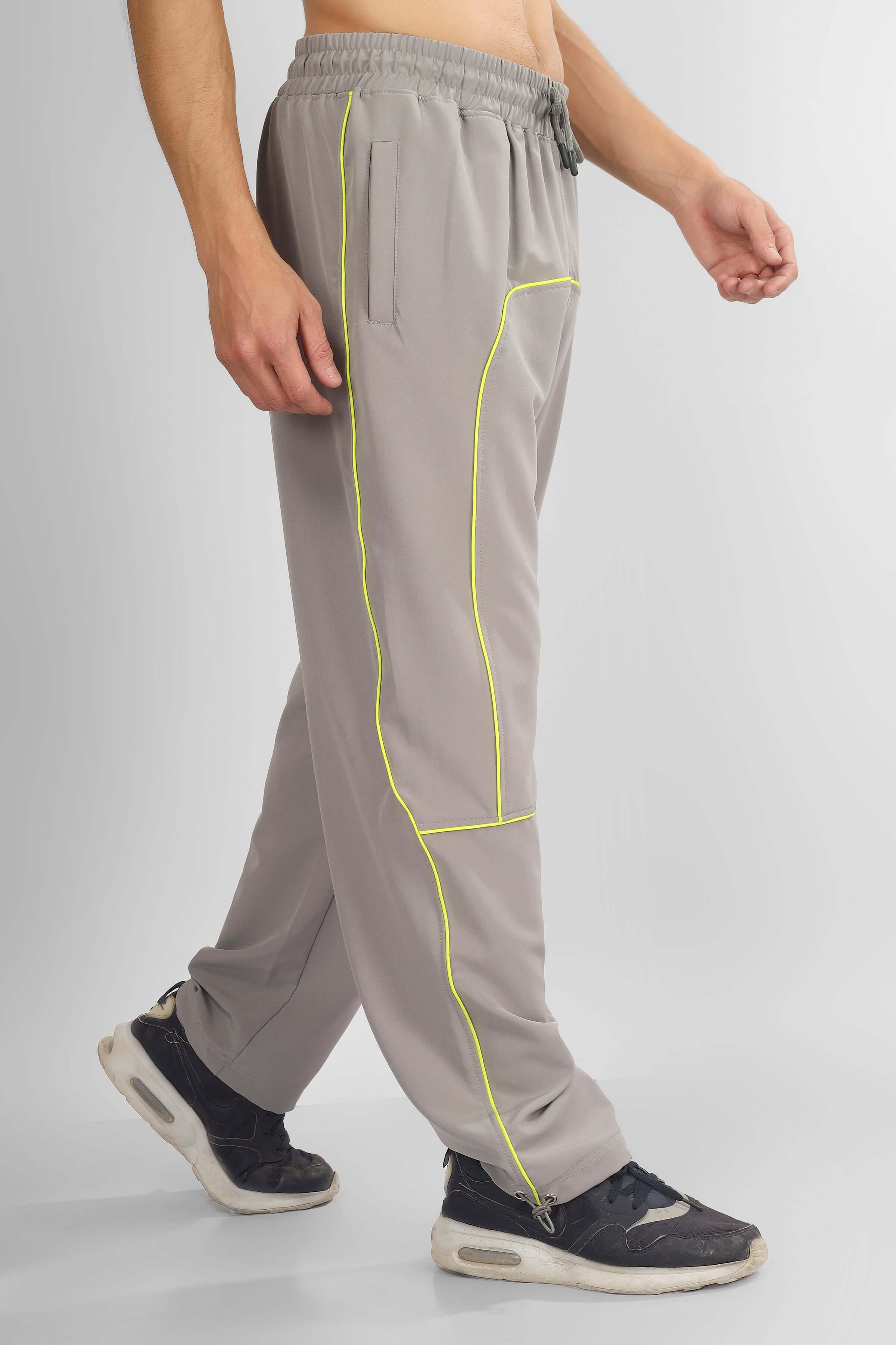 Grey parachute cargo pants with neon yellow accents, shown from the side, worn by a model. Customize fit option available.