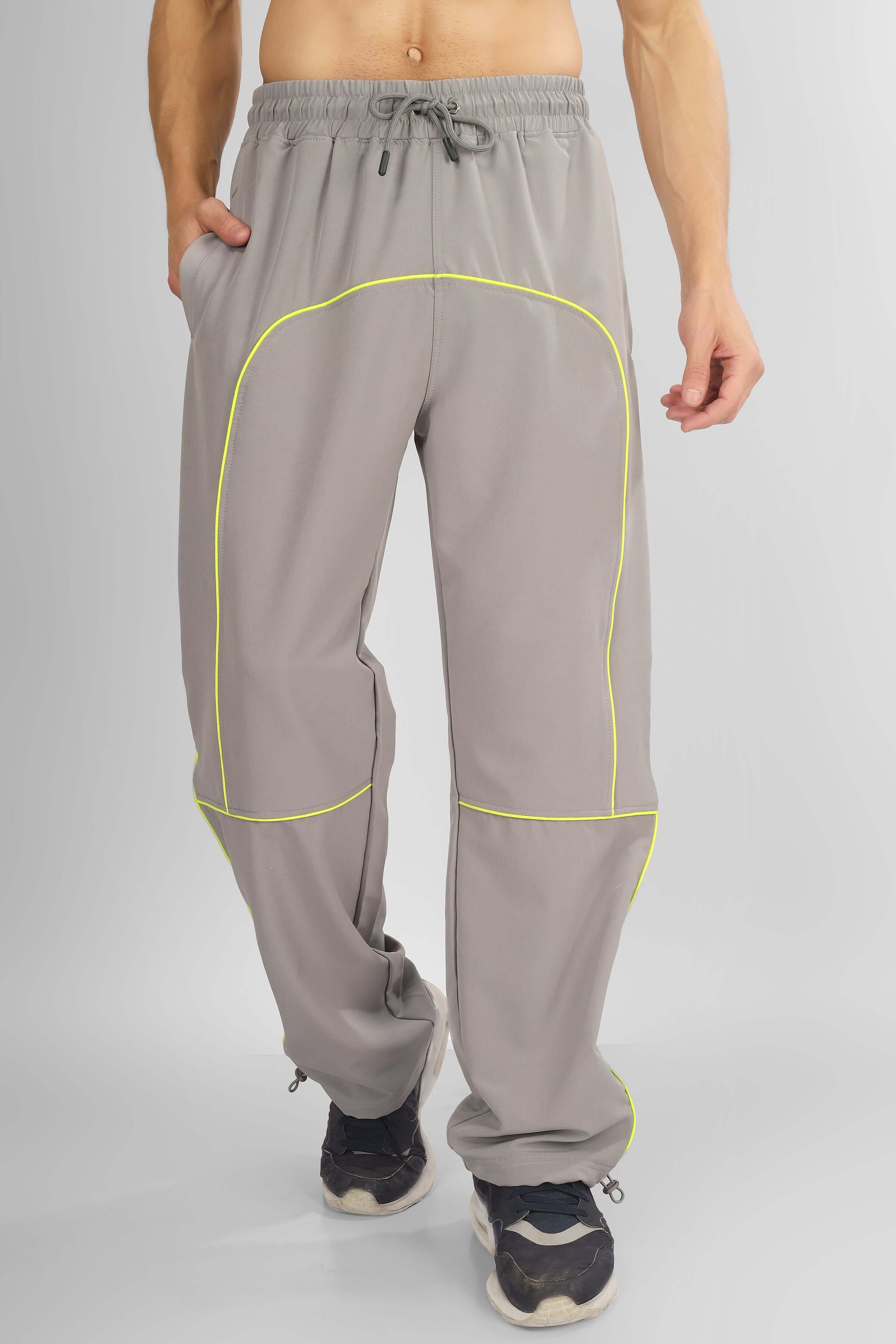 Model wearing grey SCOOP Parachute Cargo Pants with neon accents, showcasing a relaxed fit and adjustable waistband for custom sizing.