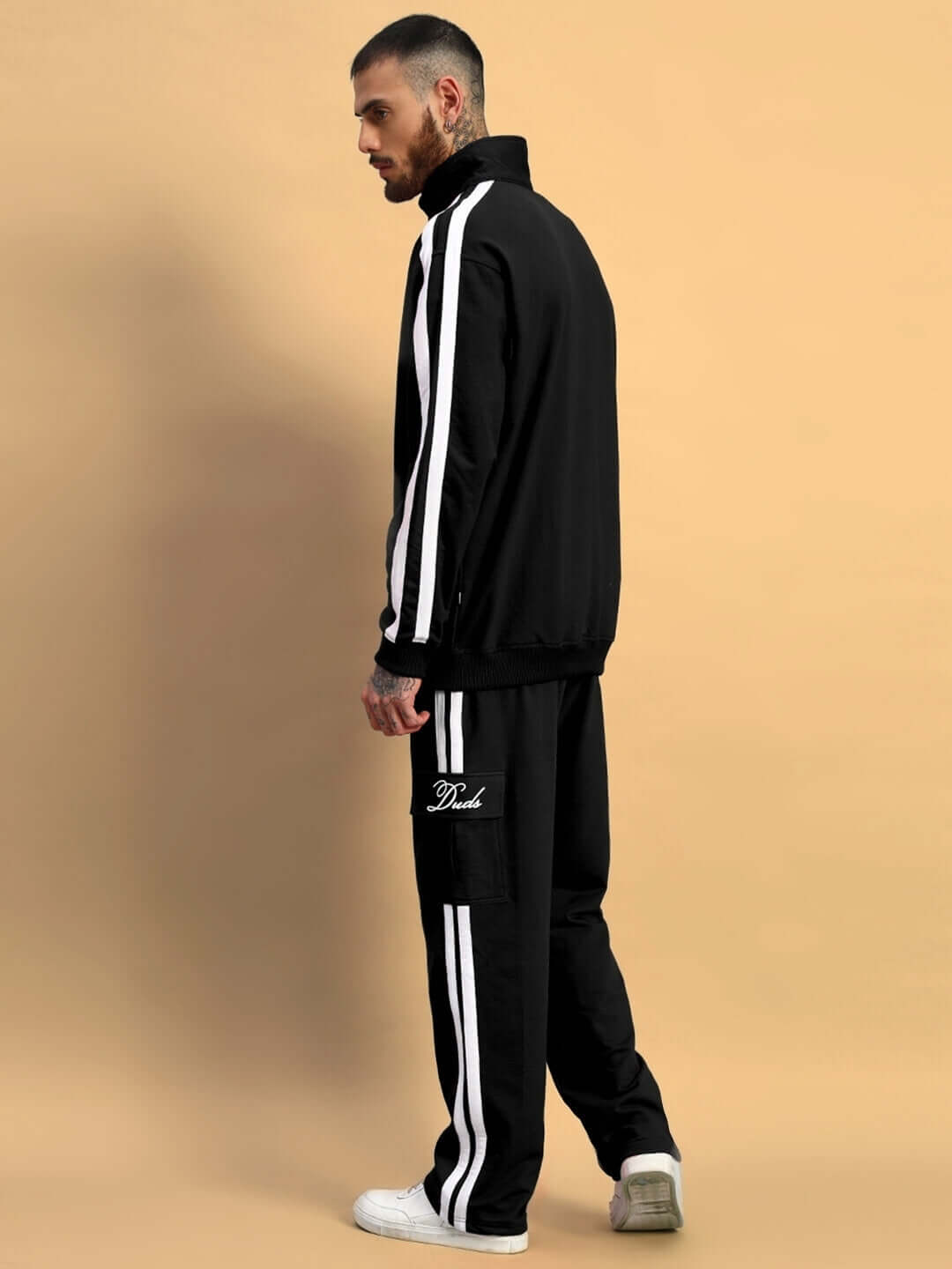 Man wearing WEARDUDS SCOTIA CO-ORD SET BLACK, black cotton terry fabric, side stripes on jacket and pants, casual streetwear fashion