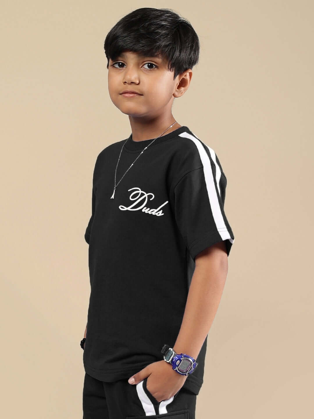 Child wearing SCOTIA T-SHIRT FOR BOYS & GIRLS BLACK by Duds, featuring white stripes and logo, customizable fit available.