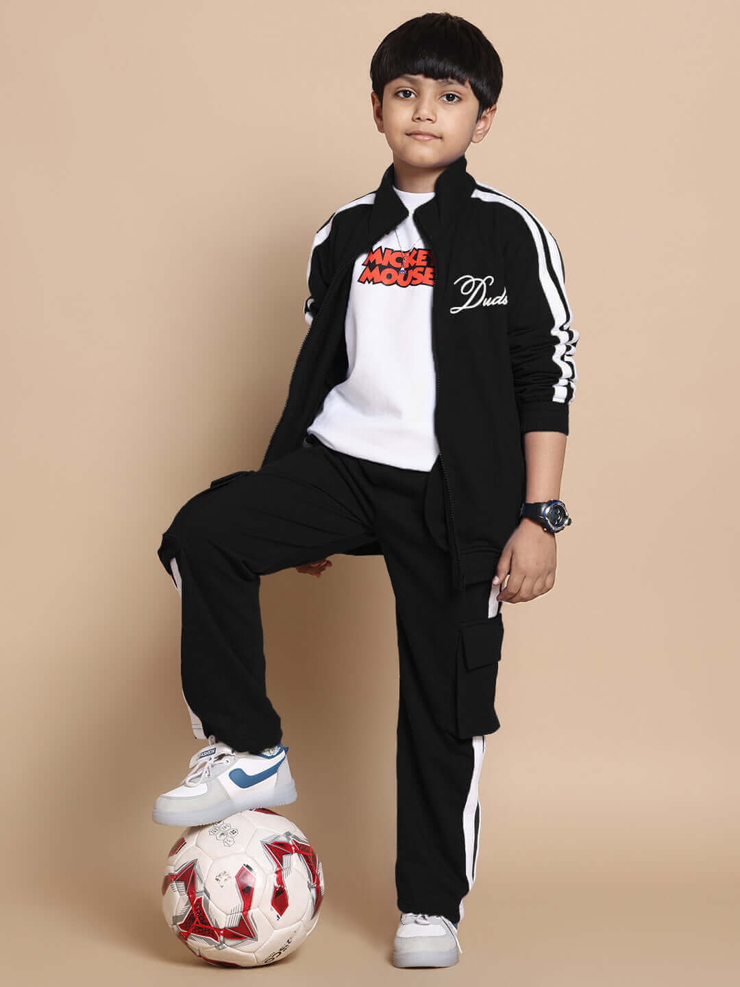 Child wearing black SCOTIA co-ord set, featuring premium cotton fabric, posing with soccer ball.