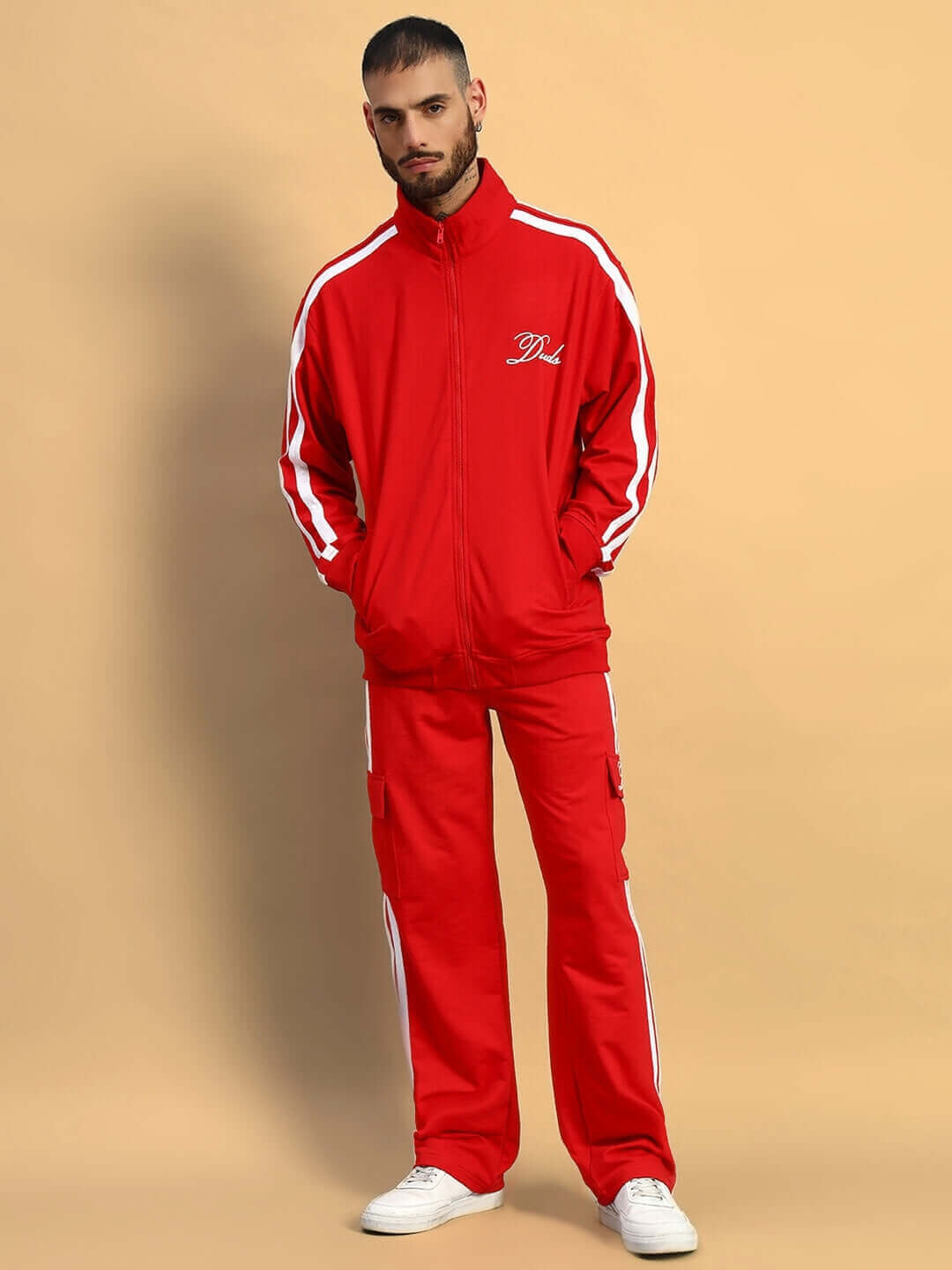 Model wearing red SCOTIA jacket with white stripes and matching pants, offered by DUDS, showcasing a sporty and customized fit.