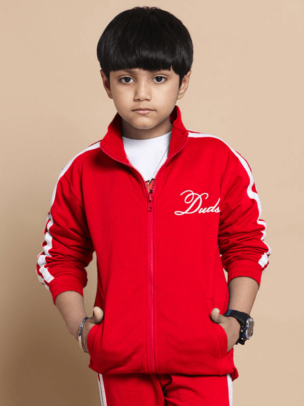 Boy wearing a red SCOTIA jacket by DUDS with pockets and stylish design, suitable for boys and girls, made to order.