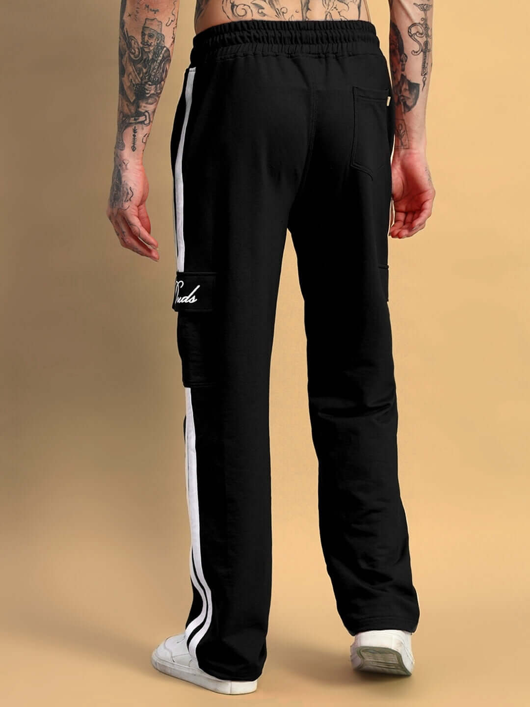 Person wearing Scotia Stripe Joggers in black, showcasing rear view with side stripe details, emphasizing comfort and style.