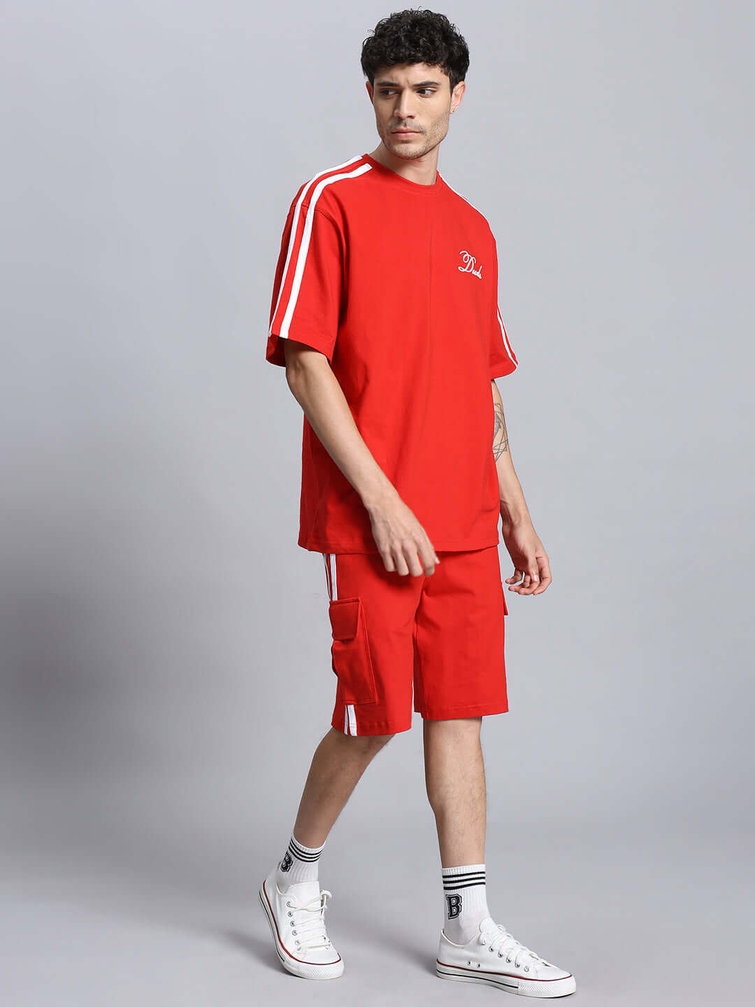 Model wearing red SCOTIA SUMMER CO-ORD SET, made of premium cotton French Terry Lycra; features short sleeves and shorts with white stripes.