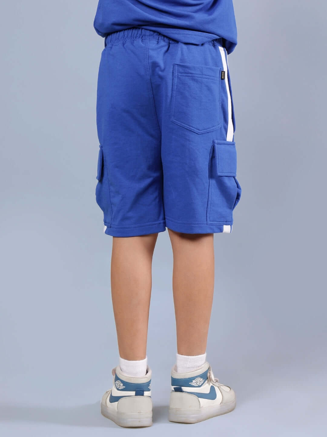 Child wearing royal blue DUDS Scotia Shorts, featuring comfortable fit with pocket details. Made with care by skilled tailors.