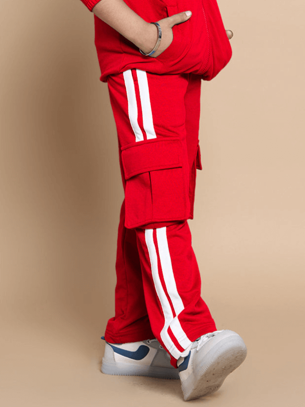 Child wearing red Scotia Stripe Joggers with white stripes, featuring cargo pockets, designed for boys and girls by DUDS.