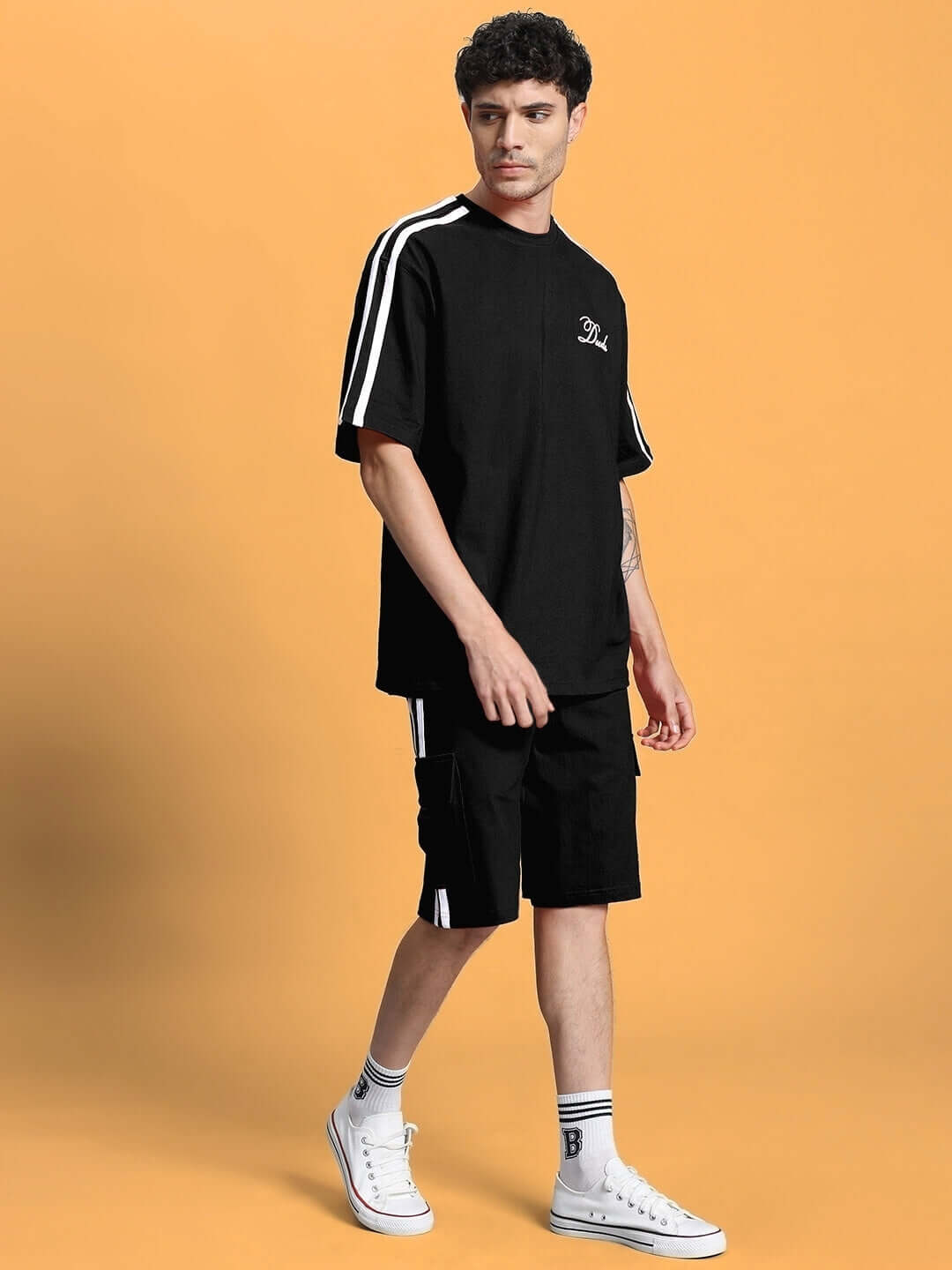 Model wearing SCOTIA SUMMER CO-ORD SET BLACK with cotton fabric and white stripe accents.