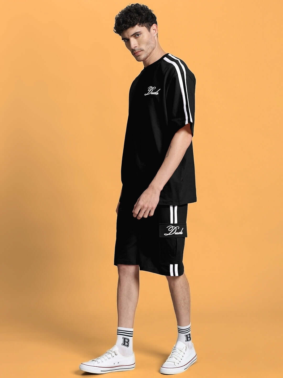 Model wearing SCOTIA SUMMER CO-ORD SET BLACK with premium cotton fabric, styled against an orange background