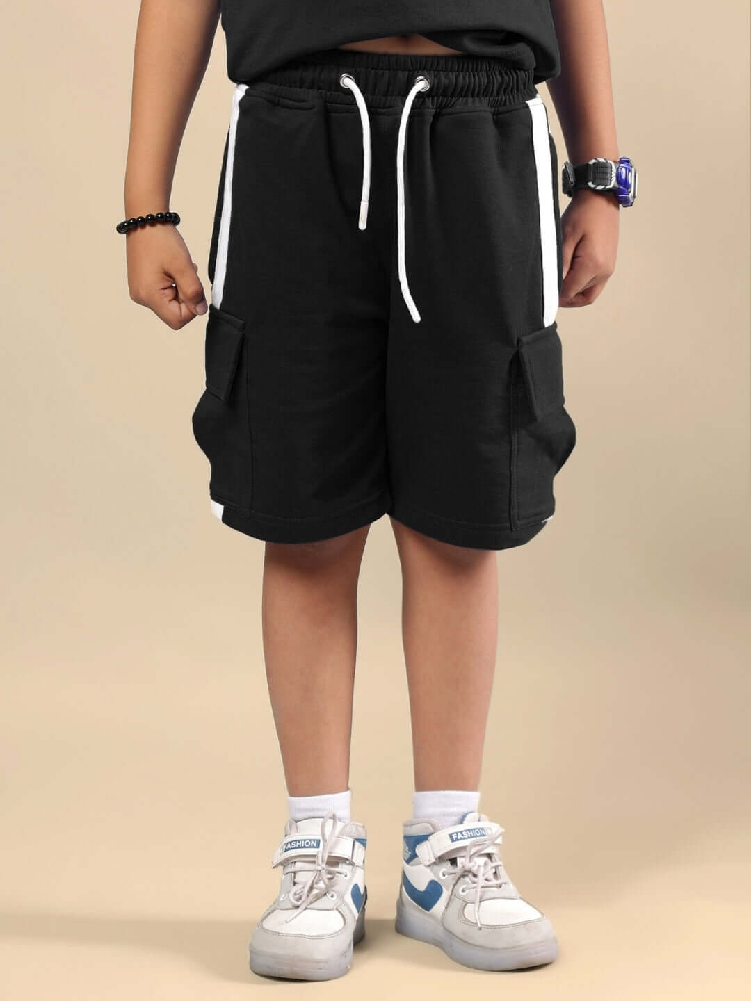 Child wearing SCOTIA SUMMER CO-ORD FOR BOYS & GIRLS BLACK with sneakers on beige background