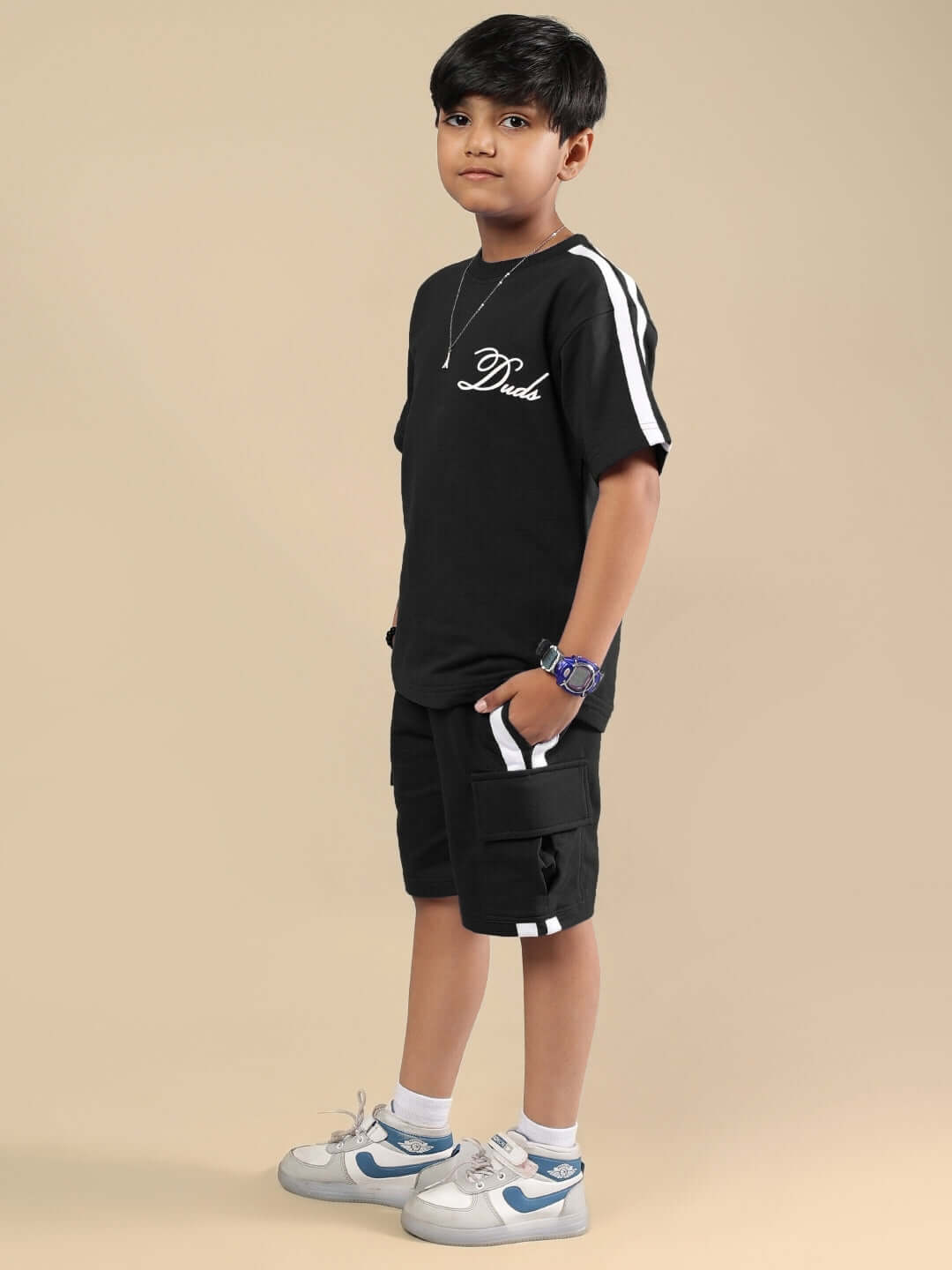 Child wearing Scotia Summer Co-ord in black by DUDS, featuring short-sleeve top and shorts, suitable for boys and girls.