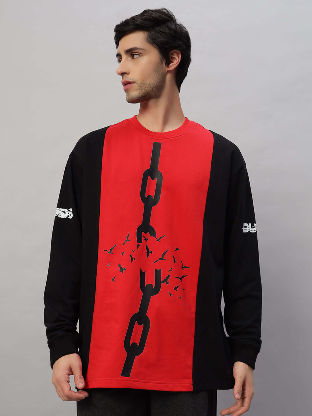 Model wearing black-red SELF-RULE oversized sweatshirt with chain and bird design, made of premium cotton and elastane blend.