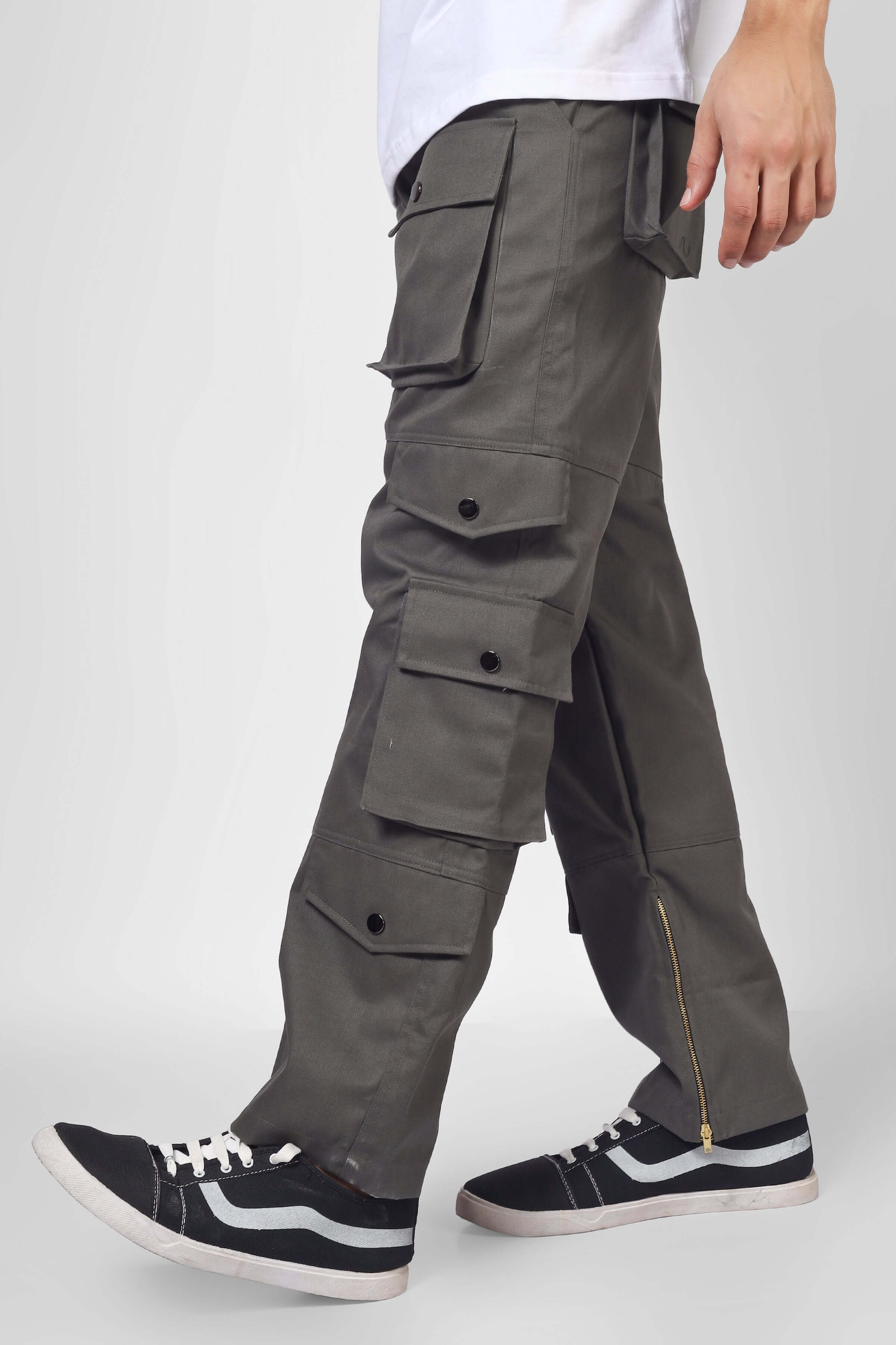 Man wearing shadow grey cargo pants with 8 pockets, showcasing modern casual style with black and white sneakers