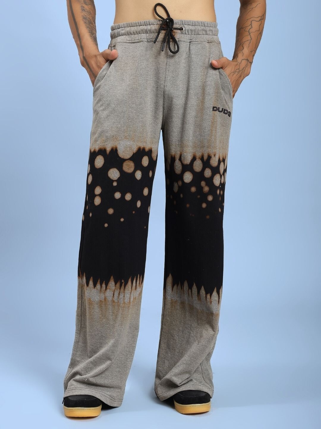 Person wearing SHADOW SWIRL TIE-DYE JOGGER BLACK with unique tie-dye pattern, showcasing comfort and style in casual setting.