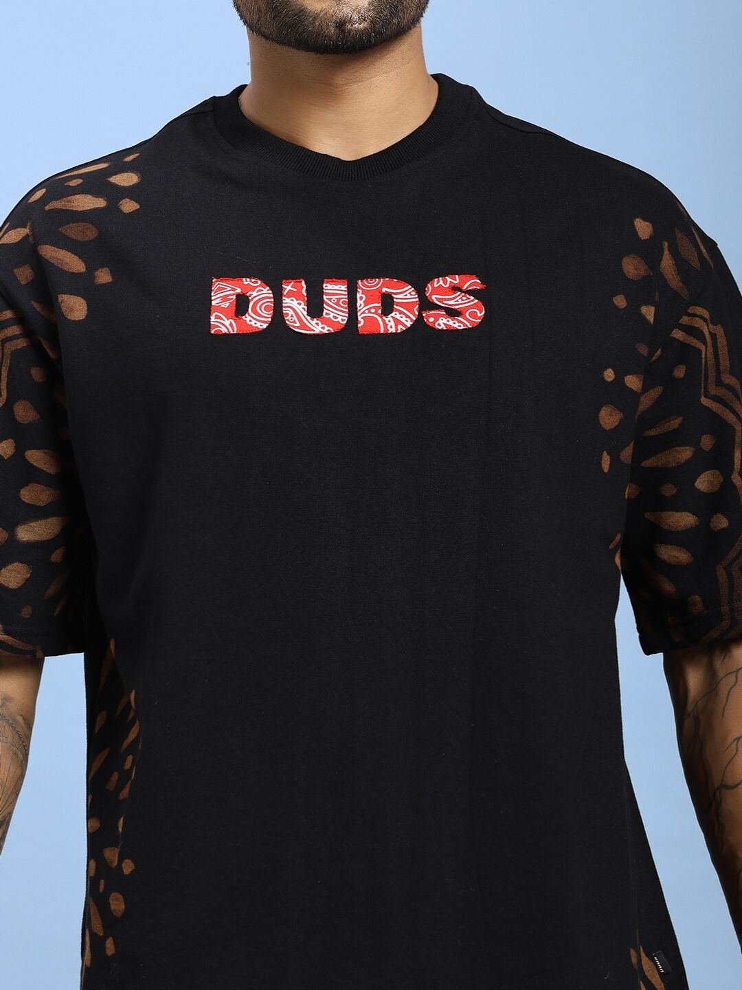 Person wearing a SHADOW SWIRL TIE-DYE T-SHIRT BLACK showcasing unique design and comfort.