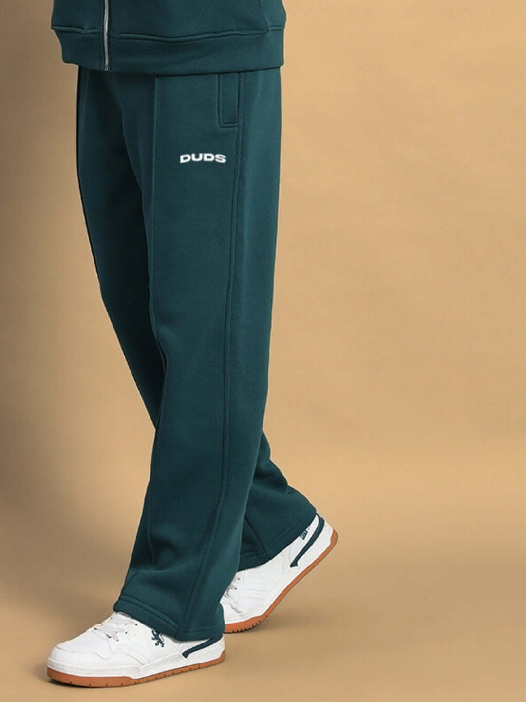 Person wearing teal green shaggy fleece jogger pants with white sneakers.
