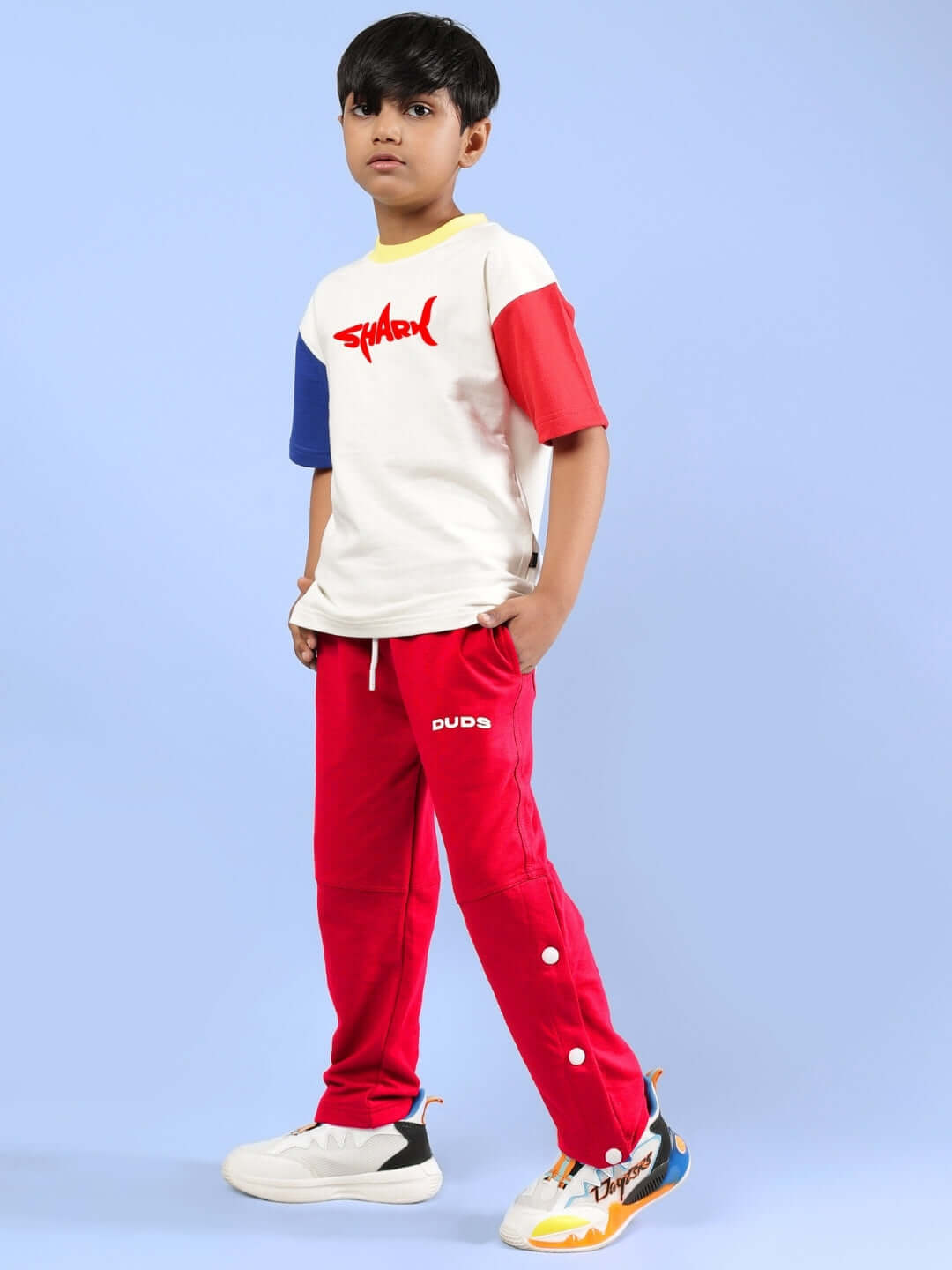 Boy wearing SHARK FISH PRINTED CO-ORD FOR BOYS & GIRLS OFF WHITE-RED outfit by DUDS, featuring off-white top and red pants.