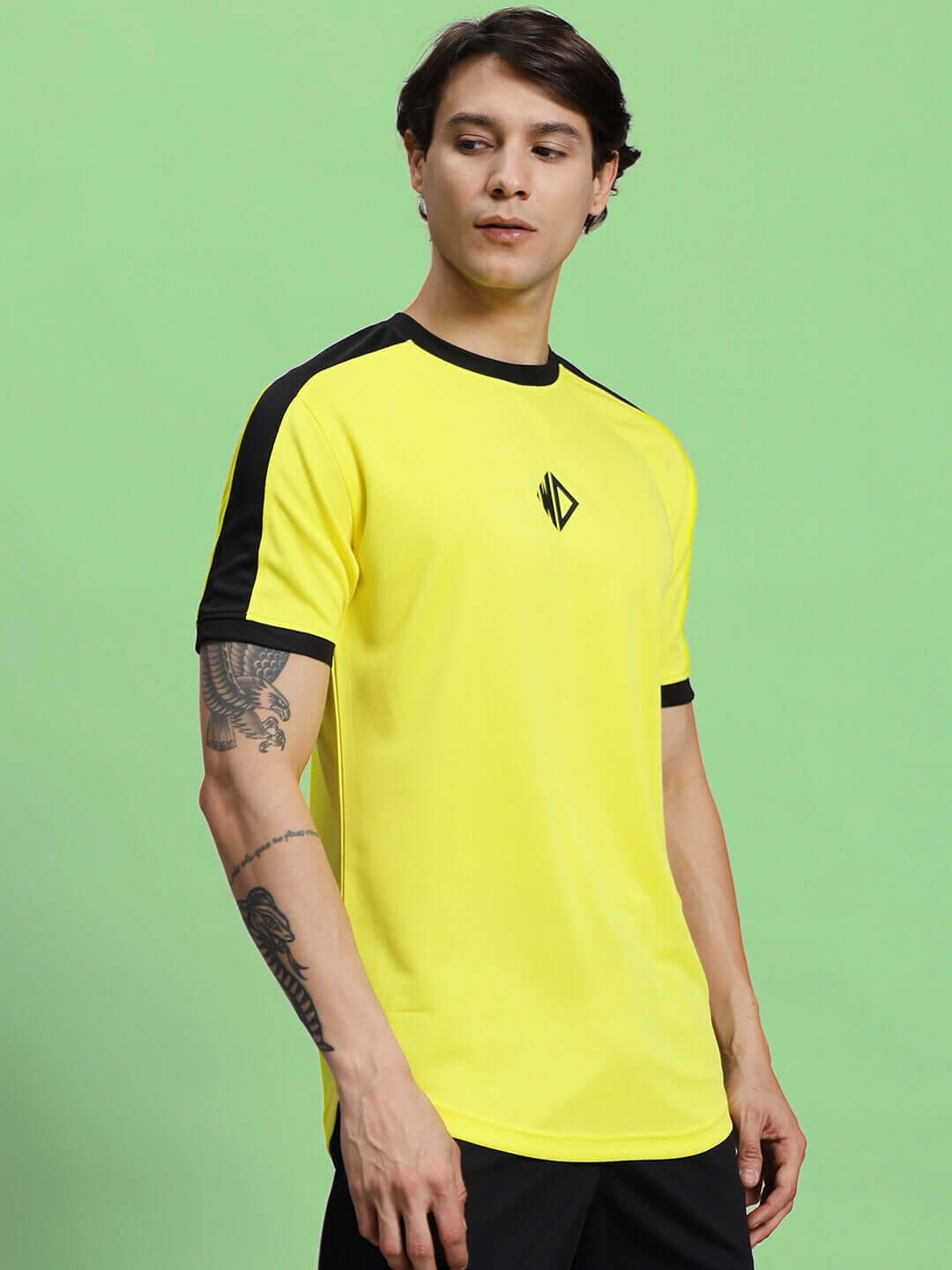 Yellow Sherpa regular fit t-shirt made with sports polyester, modeled in front of a green background. Ideal for casual wear.