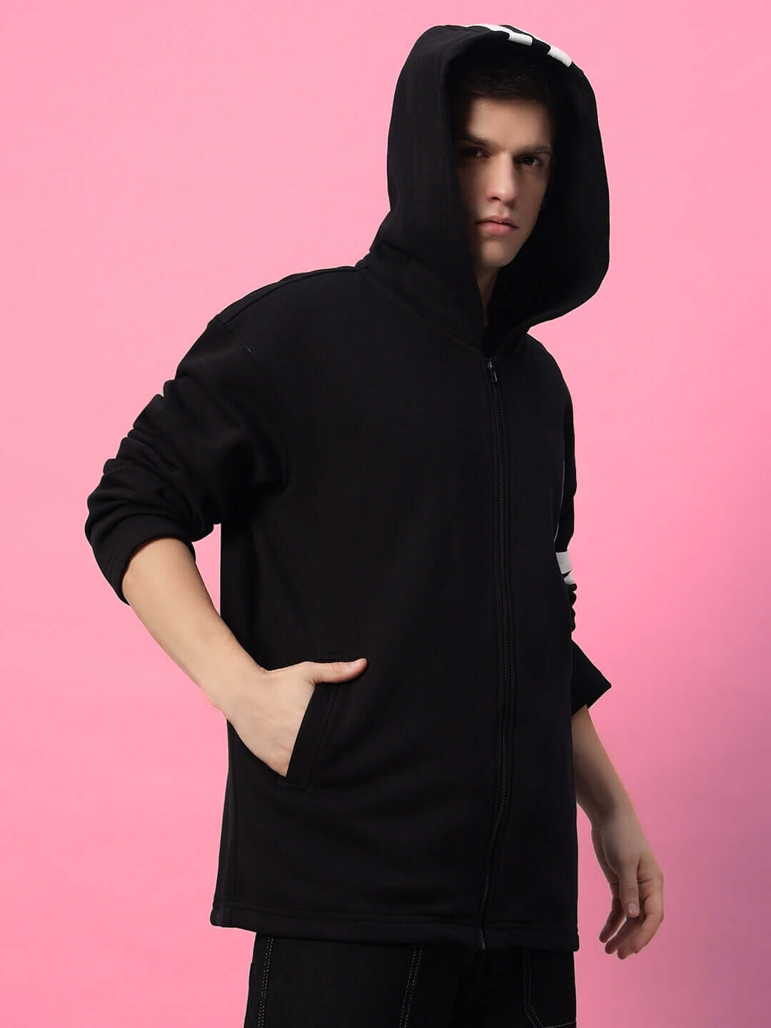 Model wearing SHINOBI ZIPPER LONG LENGTH FLEECE HOODIE BLACK against pink background