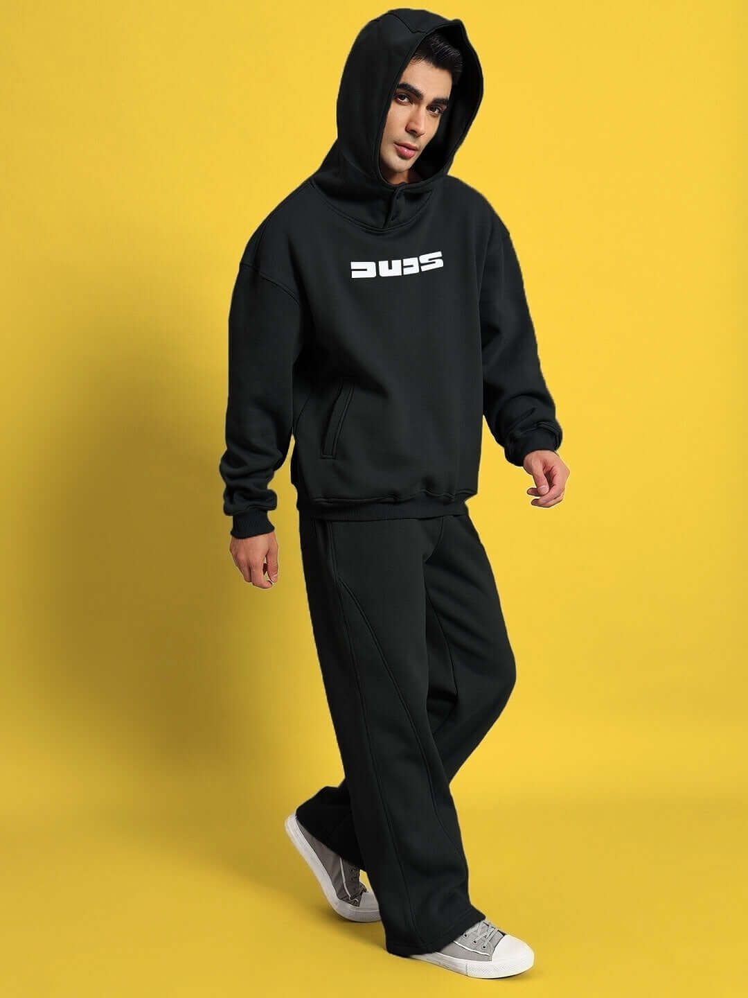 Person wearing WEARDUDS SHOOTER FLEECE CO-ORD BLACK on a yellow background.