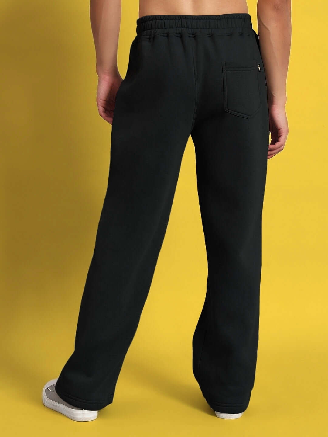 Back view of WEARDUDS SHOOTER FLEECE PANT BLACK on model against yellow background