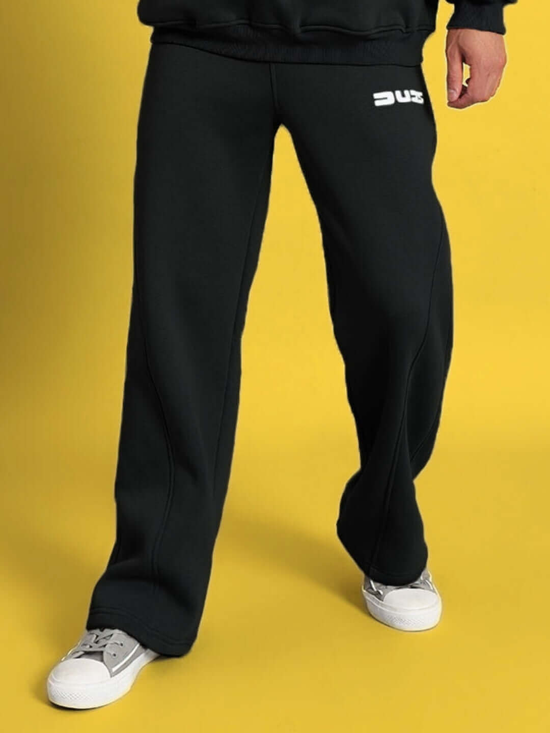 WEARDUDS SHOOTER FLEECE CO-ORD BLACK pants displayed on yellow background, tailored for comfort and style by DUDS.