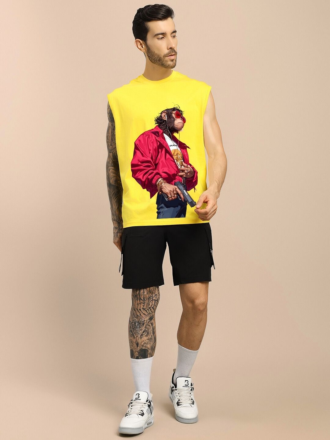 Man wearing SHOOTER MONKEY GYM T-SHIRT YELLOW with monkey print design, paired with black shorts and white sneakers, posing against a neutral background.