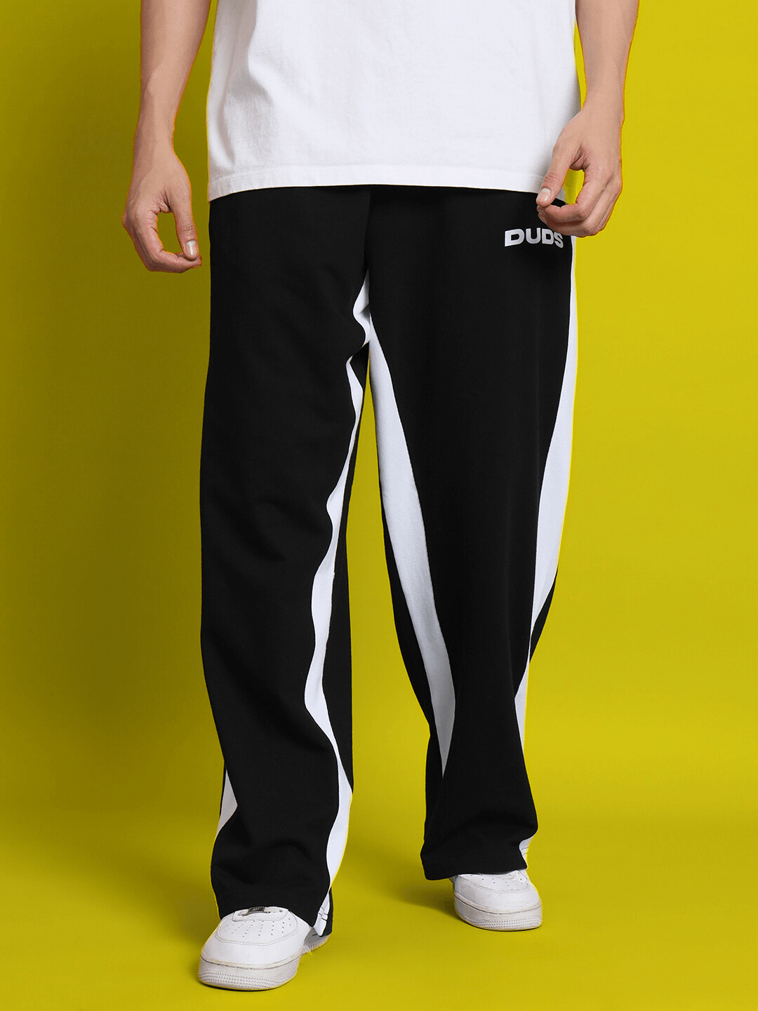Black side seam baggy joggers from DUDS with a striking white stripe design, ideal for casual and comfortable wear. Made to order.