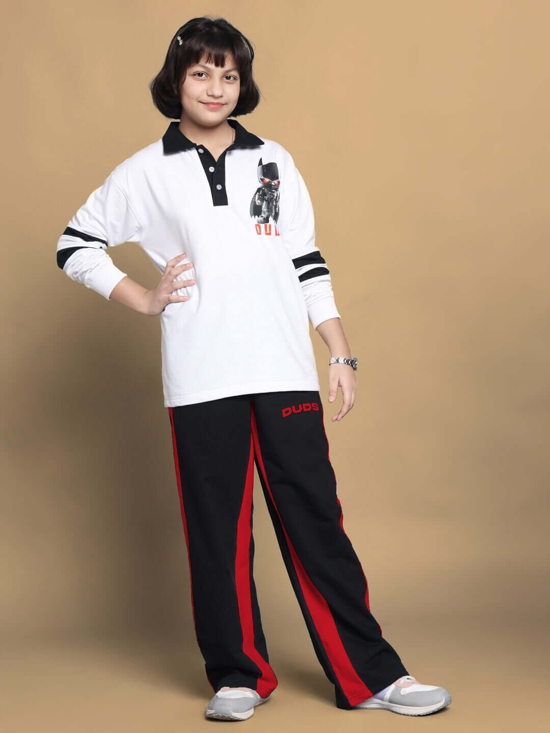 Child wearing black-red side seam baggy jogger for boys and girls, paired with a white long-sleeve shirt. DUDS made-to-order apparel.