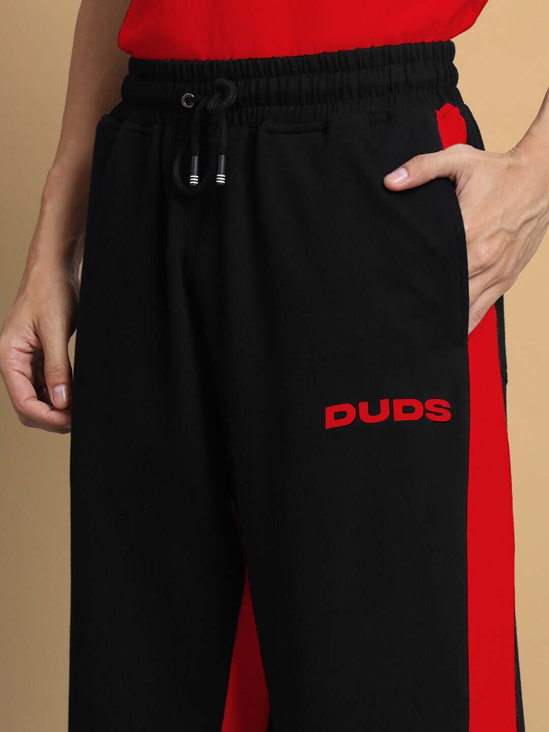 Close-up of DUDS SIDE SEAM BAGGY JOGGERS in black-red featuring side pockets and drawstring waist, showcasing tailored craftsmanship.