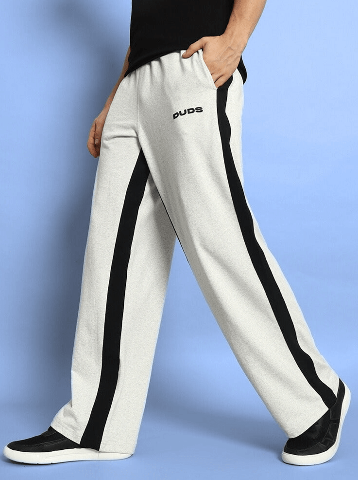 Model wearing melange grey-black side seam baggy joggers by DUDS, showcasing a casual and comfortable fit with customizable sizing options.