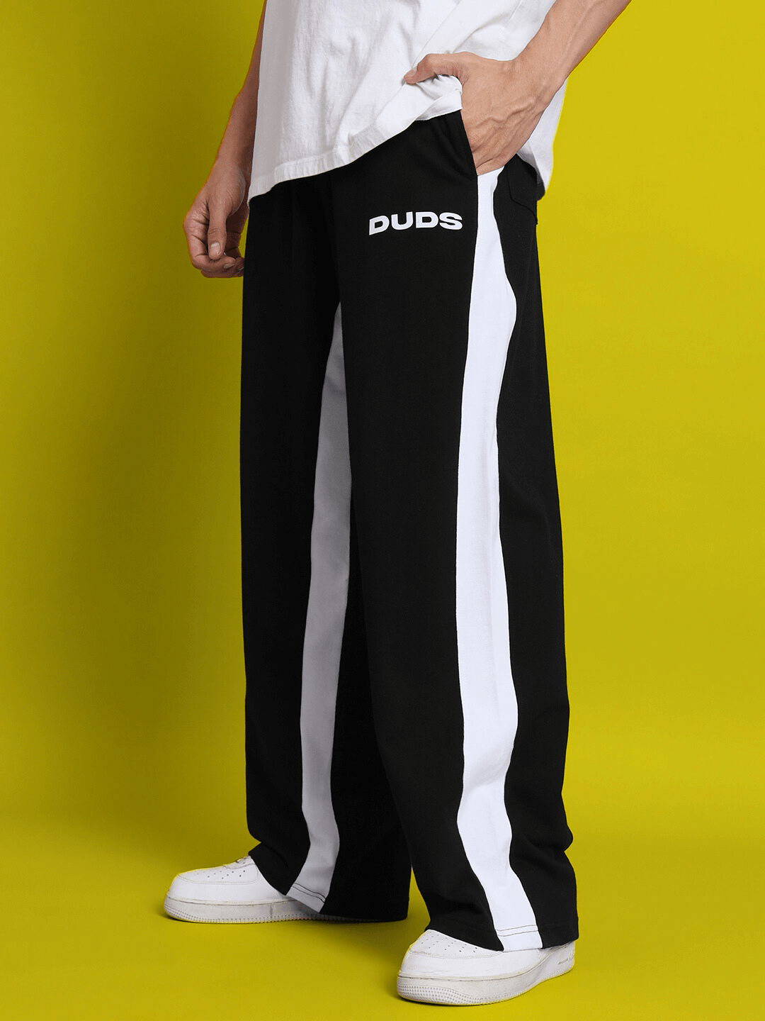Model wearing DUDS black side seam baggy joggers with white stripes, showcasing casual comfort and style.