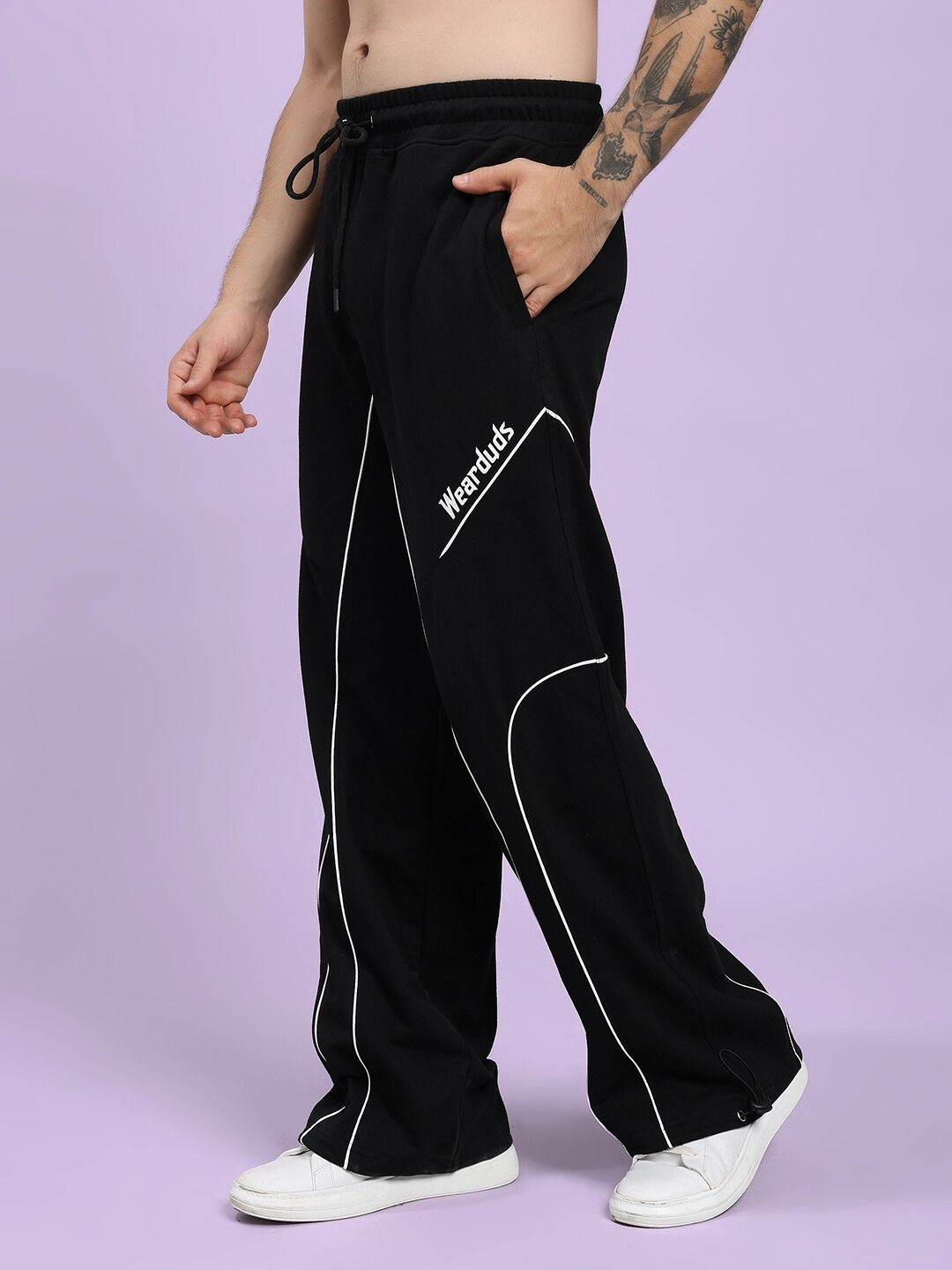 SIGNATURE PIPING JOGGERS BLACK with contrast piping, worn by model in casual pose, showcasing premium cotton-blend fabric and relaxed fit style.