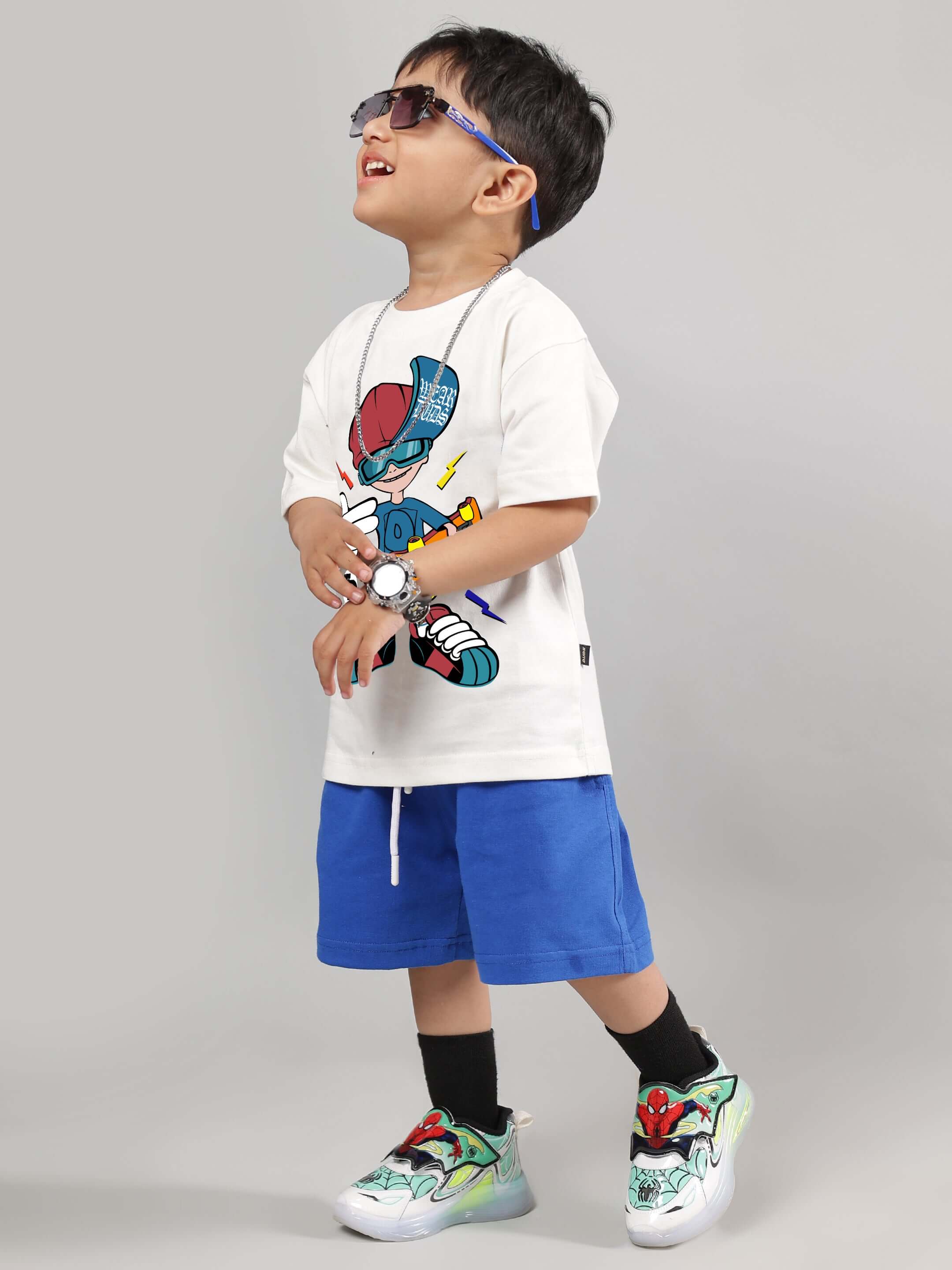 Boy wearing Skate Rider Co-ord for boys girls off white-r blue set with graphic shirt and blue shorts, showcasing comfort and street style.