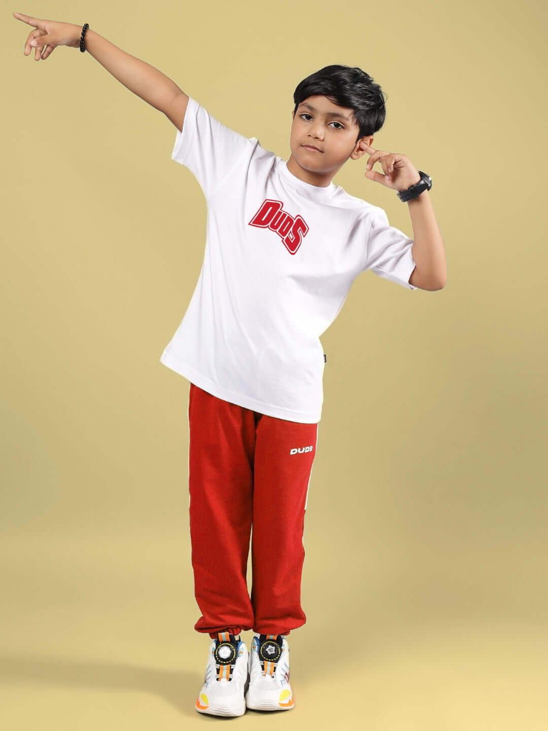 Boy wearing SKATER BANANA CO-ORD set in white and red by DUDS, standing on a yellow background.