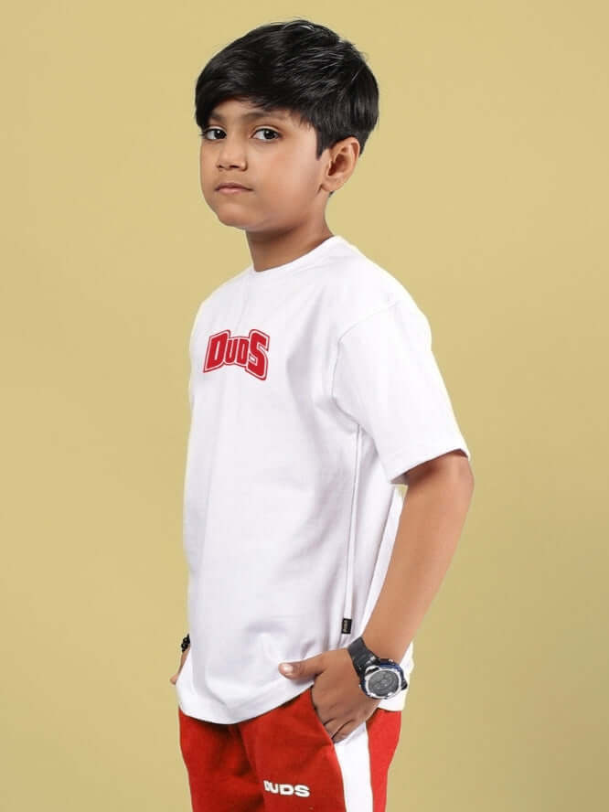 Young boy wearing a white t-shirt, posed against a yellow background.