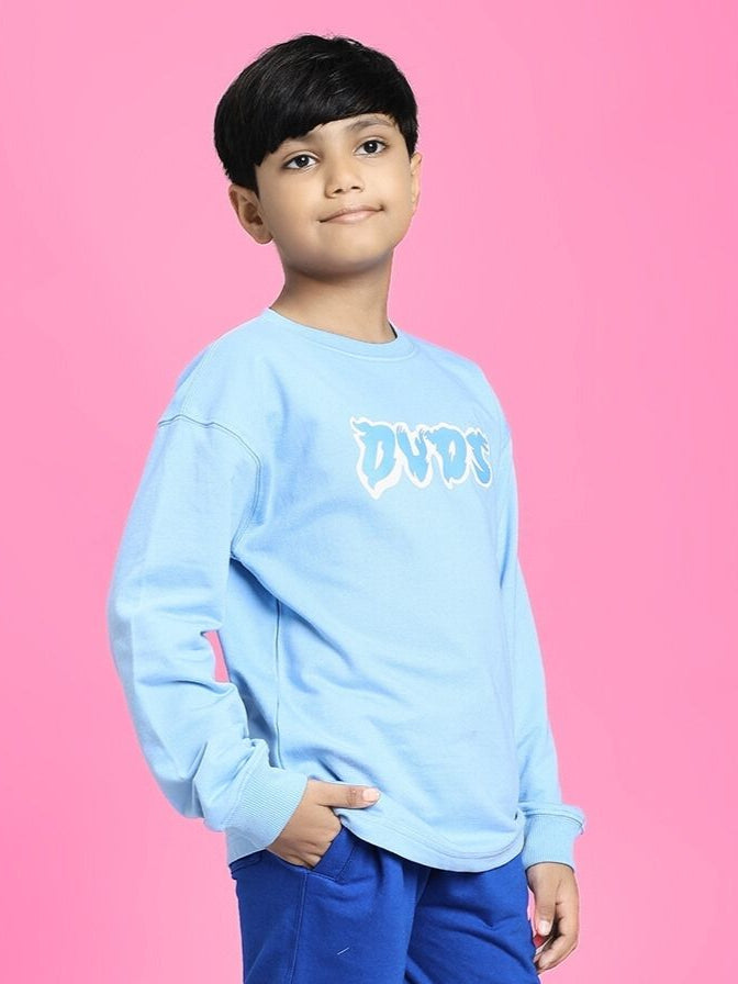 Child wearing SKATER DUCK SWEATSHIRT FOR BOYS AND GIRLS SKY BLUE against a pink background