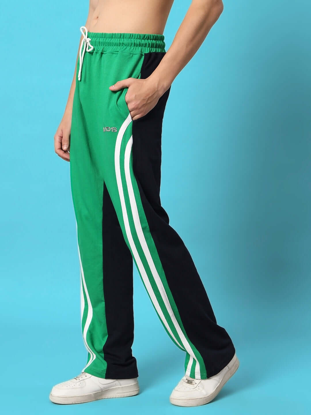 Model wearing green and black skater Korean baggy joggers with white stripes, showcasing comfortable streetwear style.