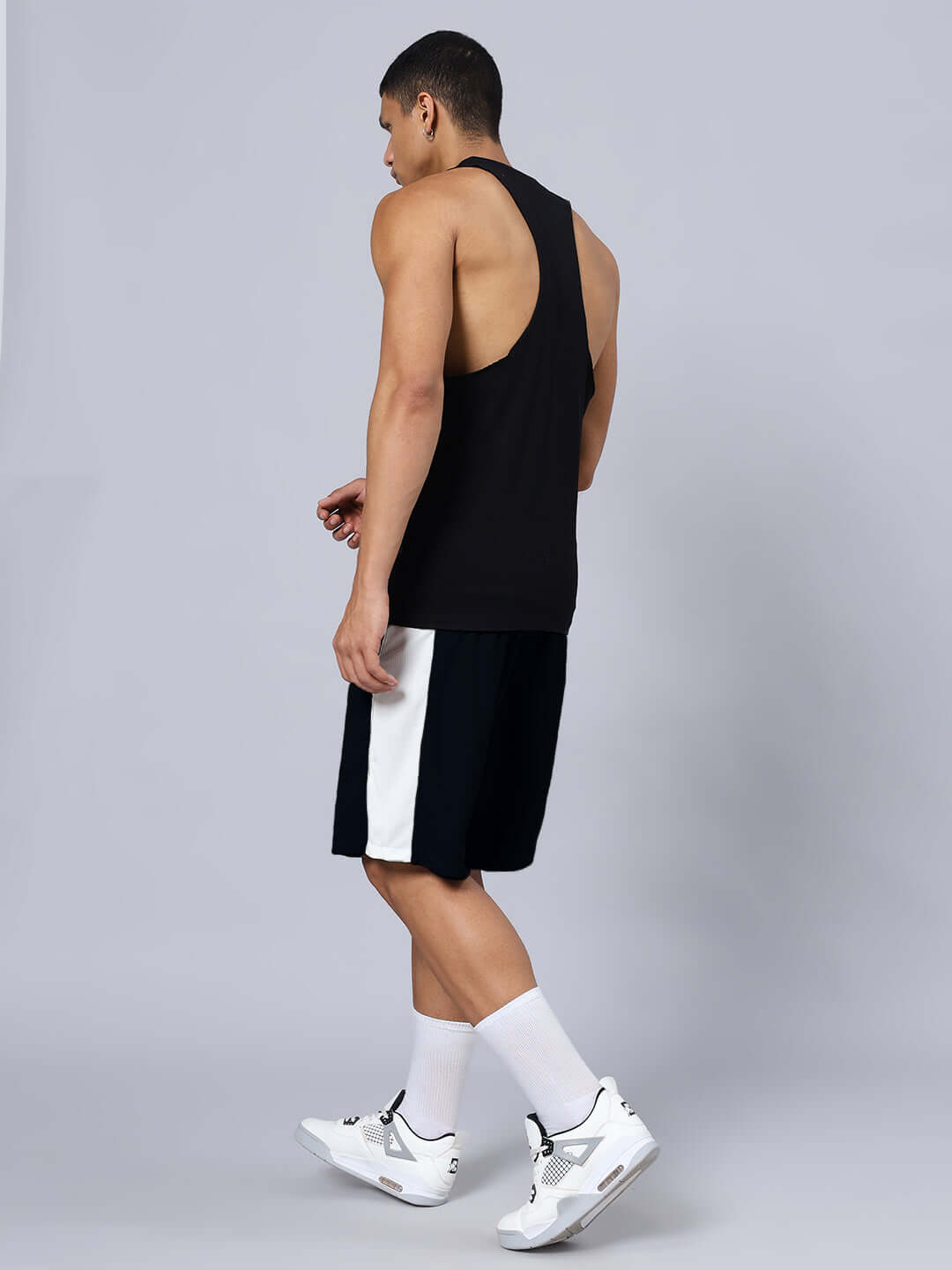 Man wearing SKELETOR GYM CO-ORD SET SELEEVELESS BLACK, featuring premium heavy gauge fabric and sports polyester bottoms, side view.