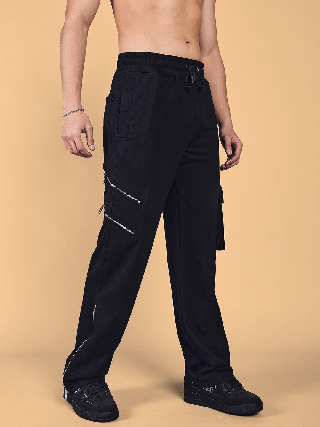 Model wearing black Skidder Cargo Pant from DUDS with tailored fit, featuring multiple pockets and modern design, available for custom order.