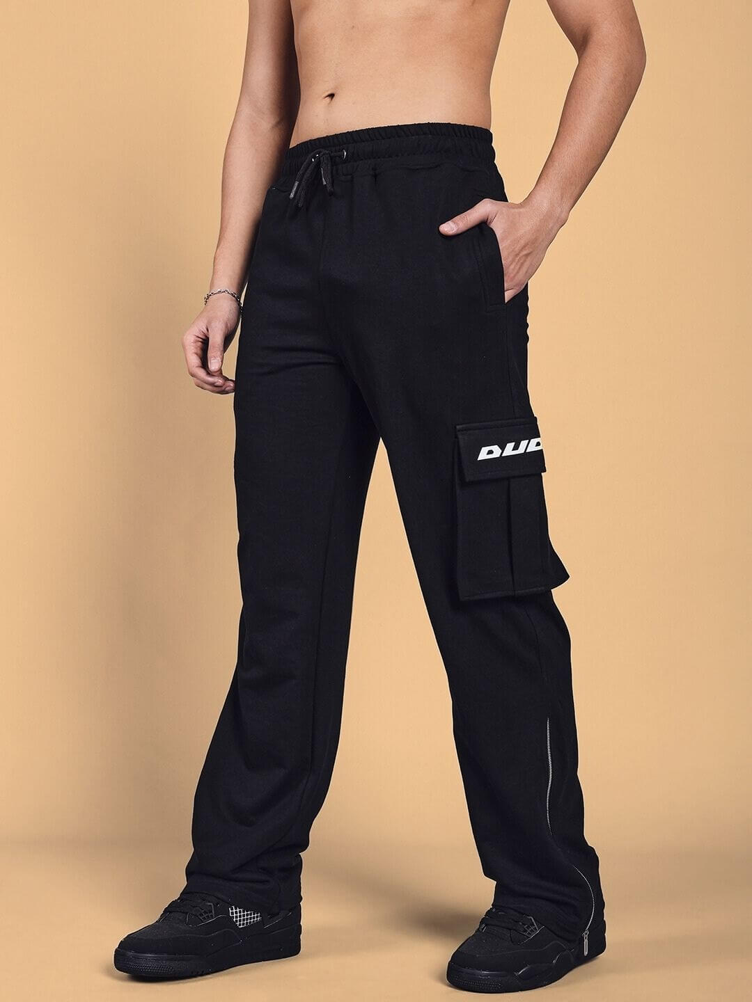 Model wearing SKIDDER Cargo Pant in black with side pocket detail; customizable and made to order for a tailored fit by DUDS.