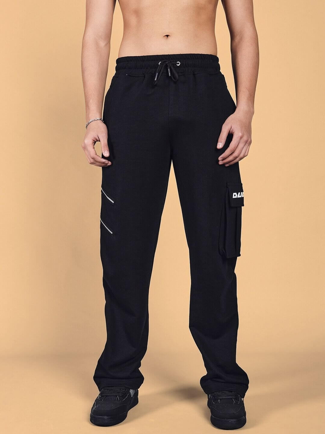 Black Skidder Cargo Pants with custom fit option by DUDS, featuring side pockets and drawstring waist; made to order.